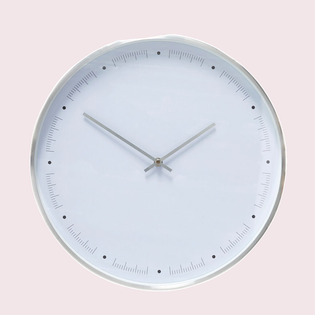 Hübsch Time wandklok wit tegen een zachte pastelachtergrond (poederroze)
