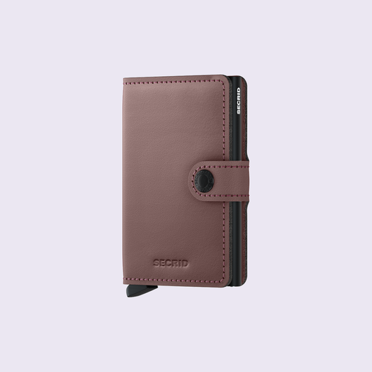 Secrid Miniwallet Matte Rose tegen een zachte pastelachtergrond (lila)