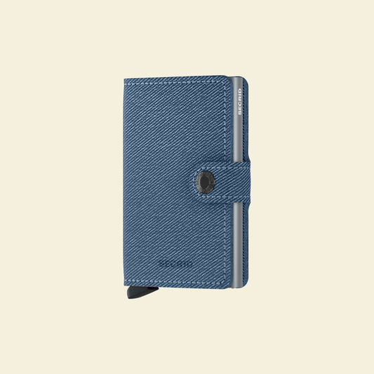 Secrid Miniwallet Twist Jeans Blue tegen een zachte pastelachtergrond (botergeel)