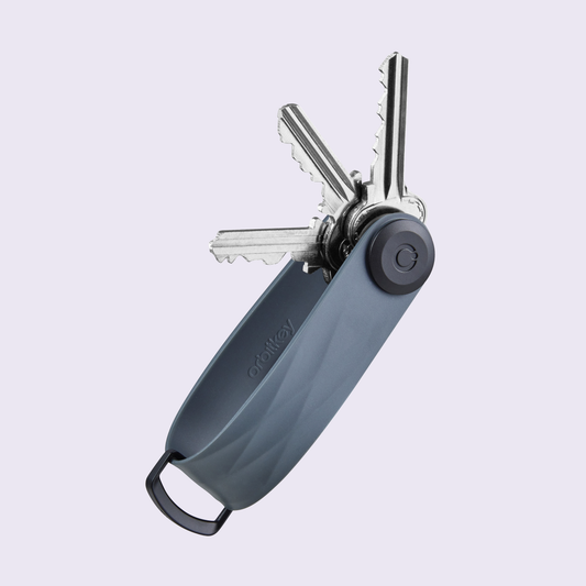 Orbitkey Sleutelorganizer Active tegen een zachte pastelachtergrond (lila)