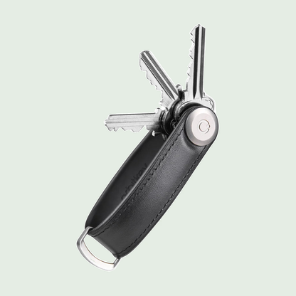 Orbitkey Key Organiser Hybrid Leather Black tegen een zachte pastelachtergrond (saliegroen)