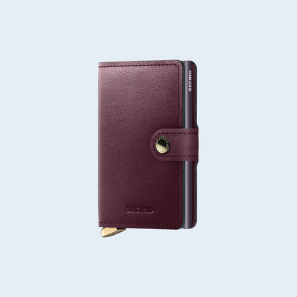 Secrid Premium Miniwallet Dusk Bordeaux tegen een zachte pastelachtergrond (lichtblauw)