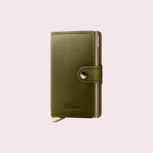 Secrid Premium Miniwallet Dusk Olive tegen een zachte pastelachtergrond (poederroze)