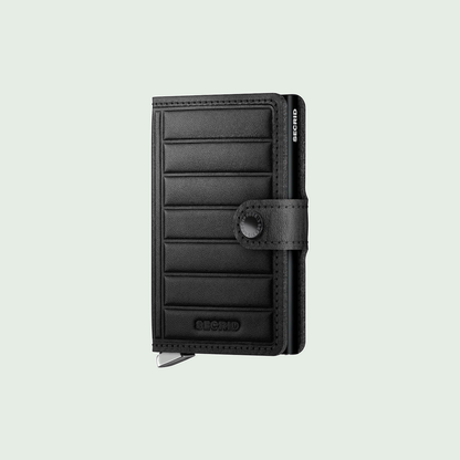 Secrid Premium Miniwallet Emboss Lines Black tegen een zachte pastelachtergrond (saliegroen)