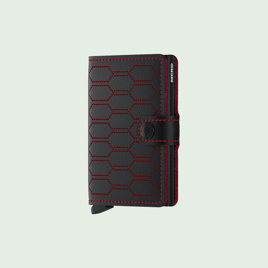 Secrid Miniwallet Fuel Black-Red tegen een zachte pastelachtergrond (saliegroen)