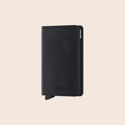 Secrid Slimwallet Vintage Black tegen een zachte pastelachtergrond (perzik)