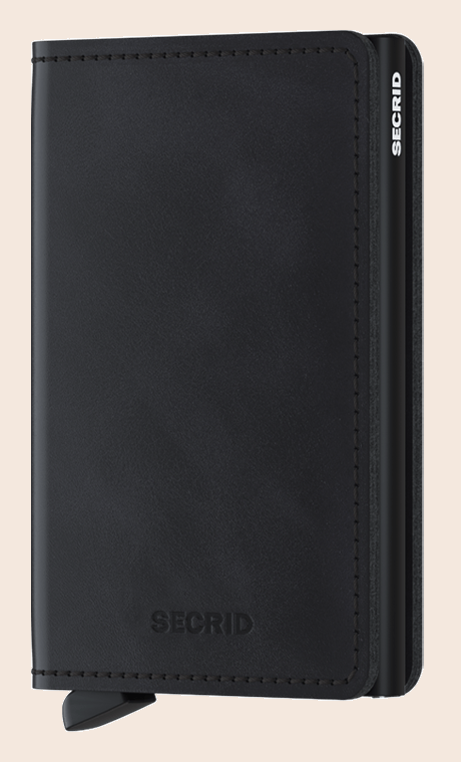 Secrid Slimwallet Vintage Black tegen een zachte pastelachtergrond (perzik)