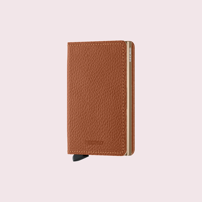 Secrid Slimwallet Veg Caramello-Sand tegen een zachte pastelachtergrond (poederroze)